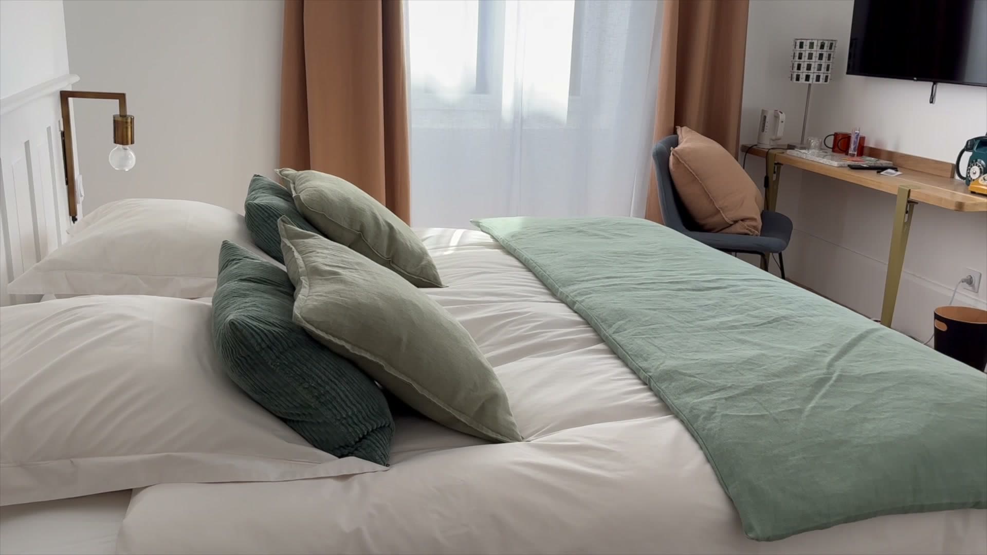 Helles Zimmer der Maison Bo Terra, gemachtes Bett mit grüner und beiger Bettwäsche